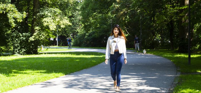 Female student walking through a public park in Munich