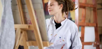 Student paints on an easel